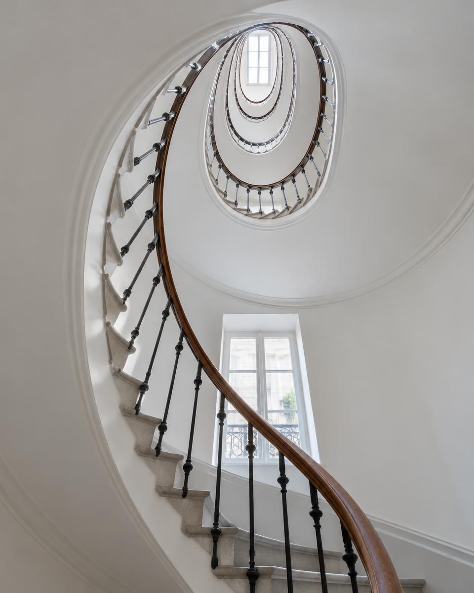 Cage d'escalier en colimaçon lumineuse d'un immeuble parisien